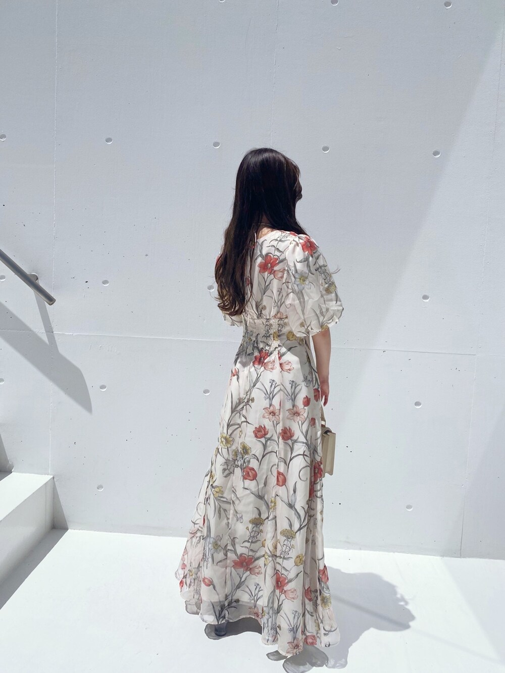 ホワイト系のハンドバッグ、ホワイト系のワンピース、ブラウン系のブーツを着用したレディースの夏コーディネートの4枚目の写真