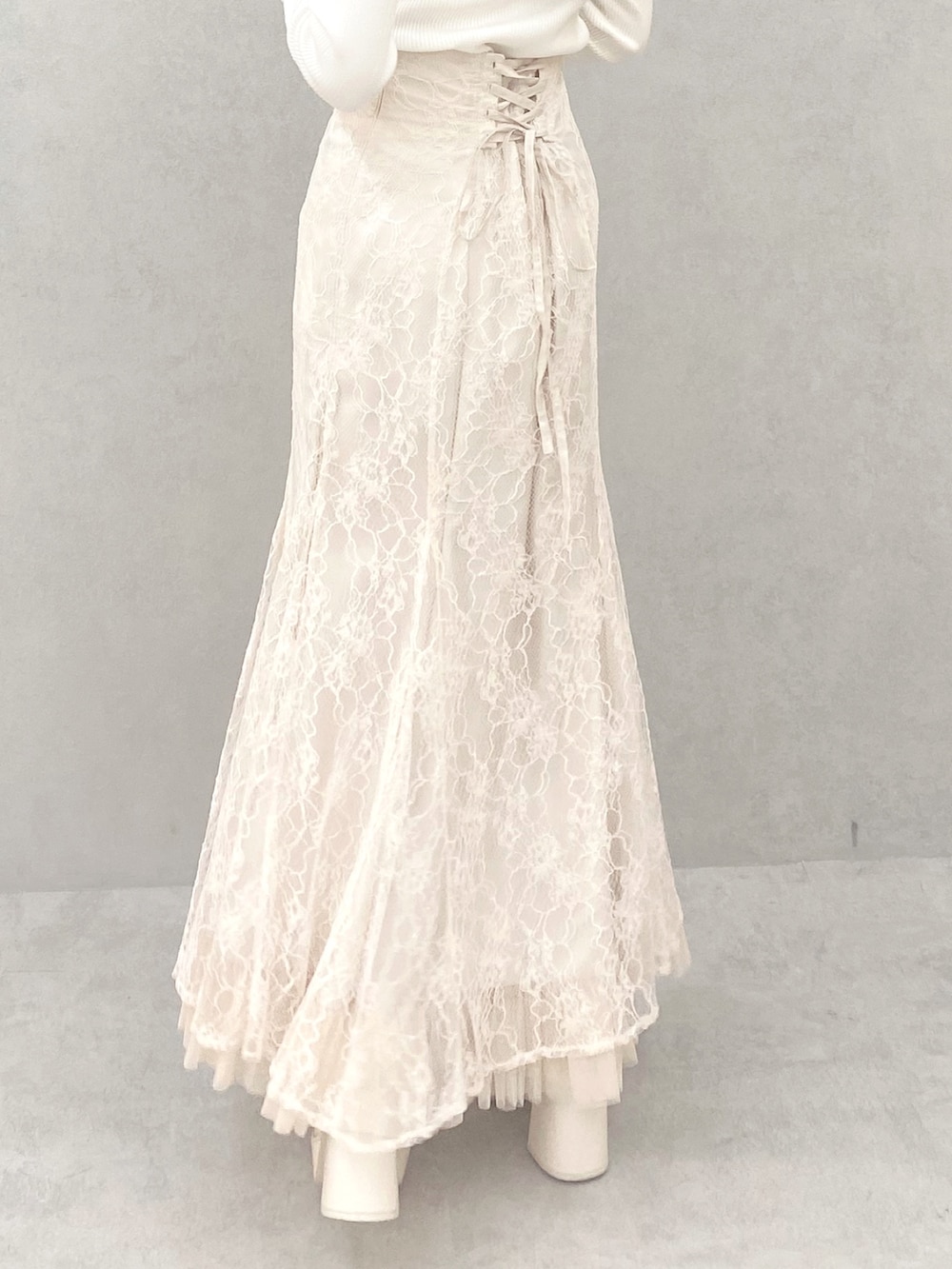 ホワイト系のブーツ、ホワイト系のニット/セーター、ホワイト系のスカートを着用したレディースの夏コーディネートの7枚目の写真