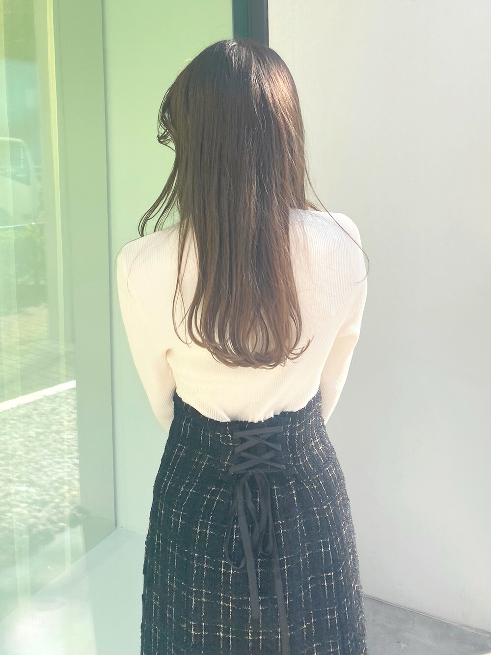 ホワイト系のブーツ、ブラック系のハンドバッグ、ブラック系のワンピースを着用したレディースの冬コーディネートの5枚目の写真