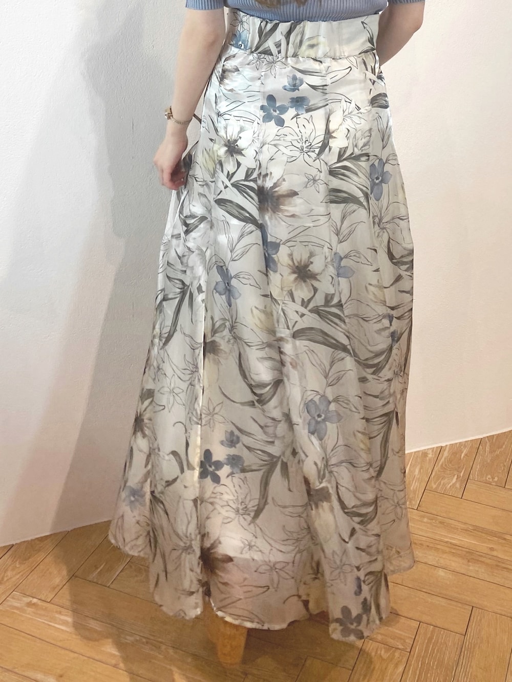 ホワイト系のサンダル、ブルー系のボストンバッグ、グリーン系のスカートを着用したレディースの春コーディネートの4枚目の写真