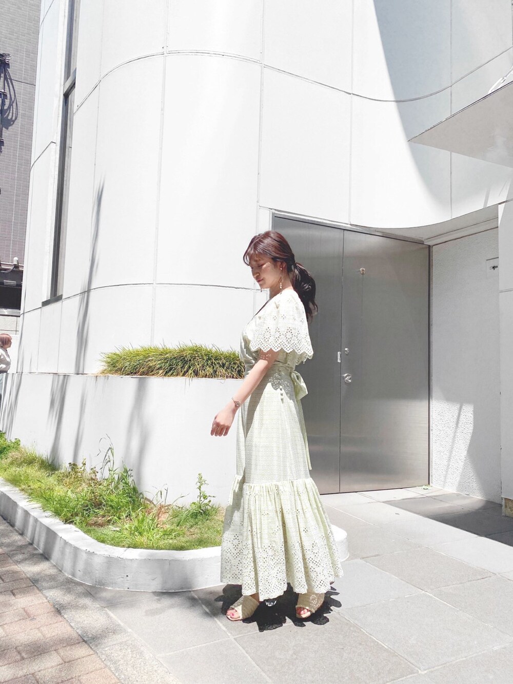 グリーン系のシャツ/ブラウス、ホワイト系のサンダル、グリーン系のスカートを着用したレディースの春コーディネートの2枚目の写真