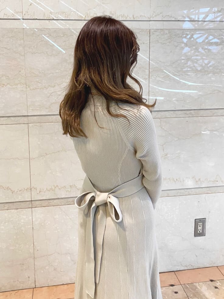 ベージュ系のワンピース、ホワイト系のハンドバッグを着用したレディースの冬コーディネートの6枚目の写真