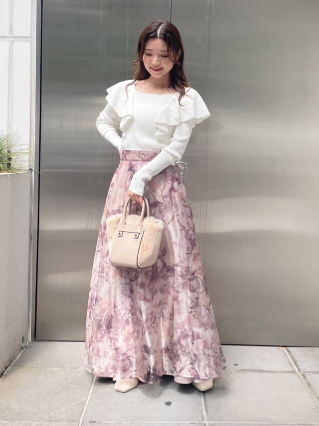 ホワイト系のハンドバッグ、ピンク系のスカート、ホワイト系のニット/セーターを着用したレディースの秋コーディネートの3枚目の写真