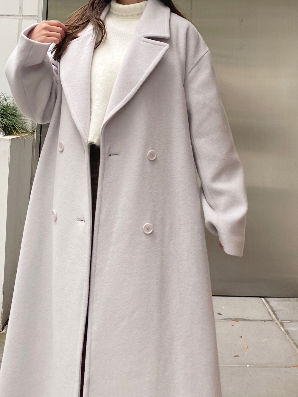 ホワイト系のニット/セーター、ベージュ系のスカート、ホワイト系のブーツを着用したレディースの秋コーディネートの7枚目の写真