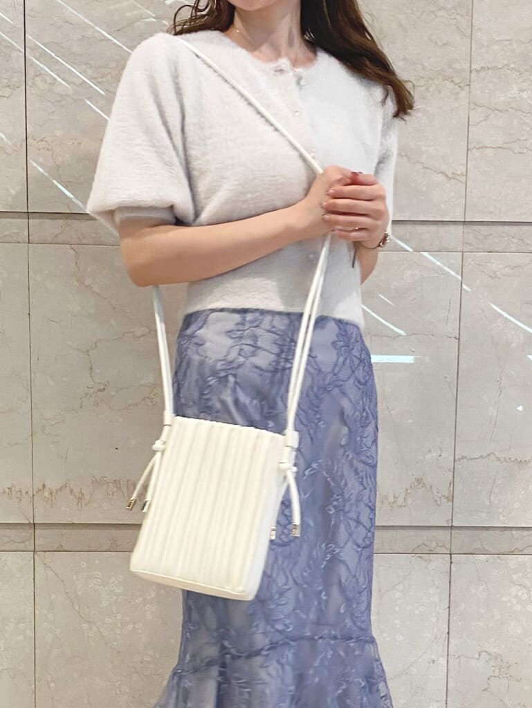 ブルー系のスカート、ホワイト系のその他シューズ、ベージュ系のショルダーバッグを着用したレディースの夏コーディネートの2枚目の写真