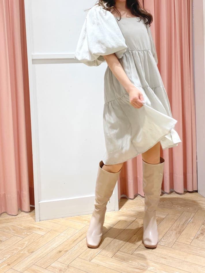 グリーン系のワンピース、ベージュ系のブーツ、ベージュ系のキャスケットを着用したレディースの秋コーディネートの6枚目の写真