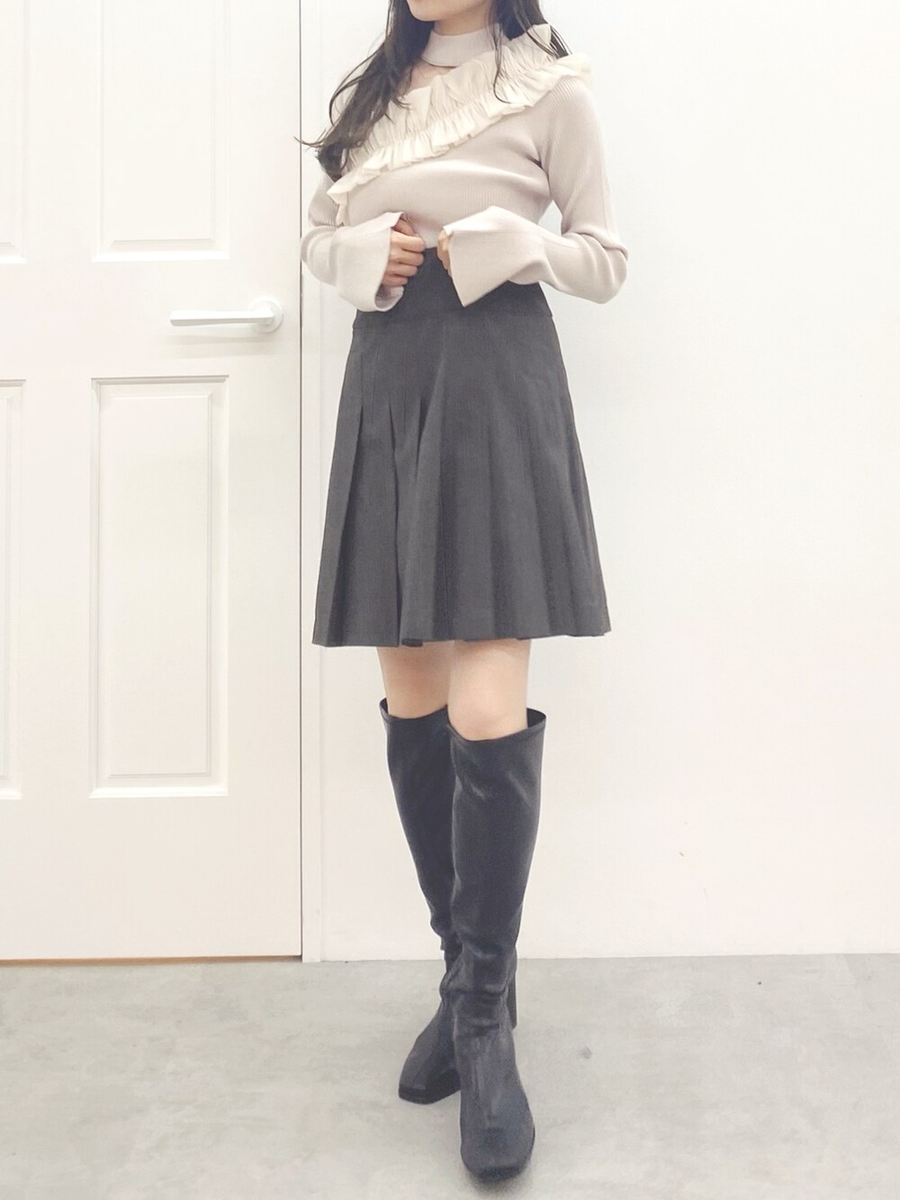 ブラック系のブーツ、ブラウン系のその他パンツ、ホワイト系のニット/セーターを着用したレディースの秋コーディネートの2枚目の写真