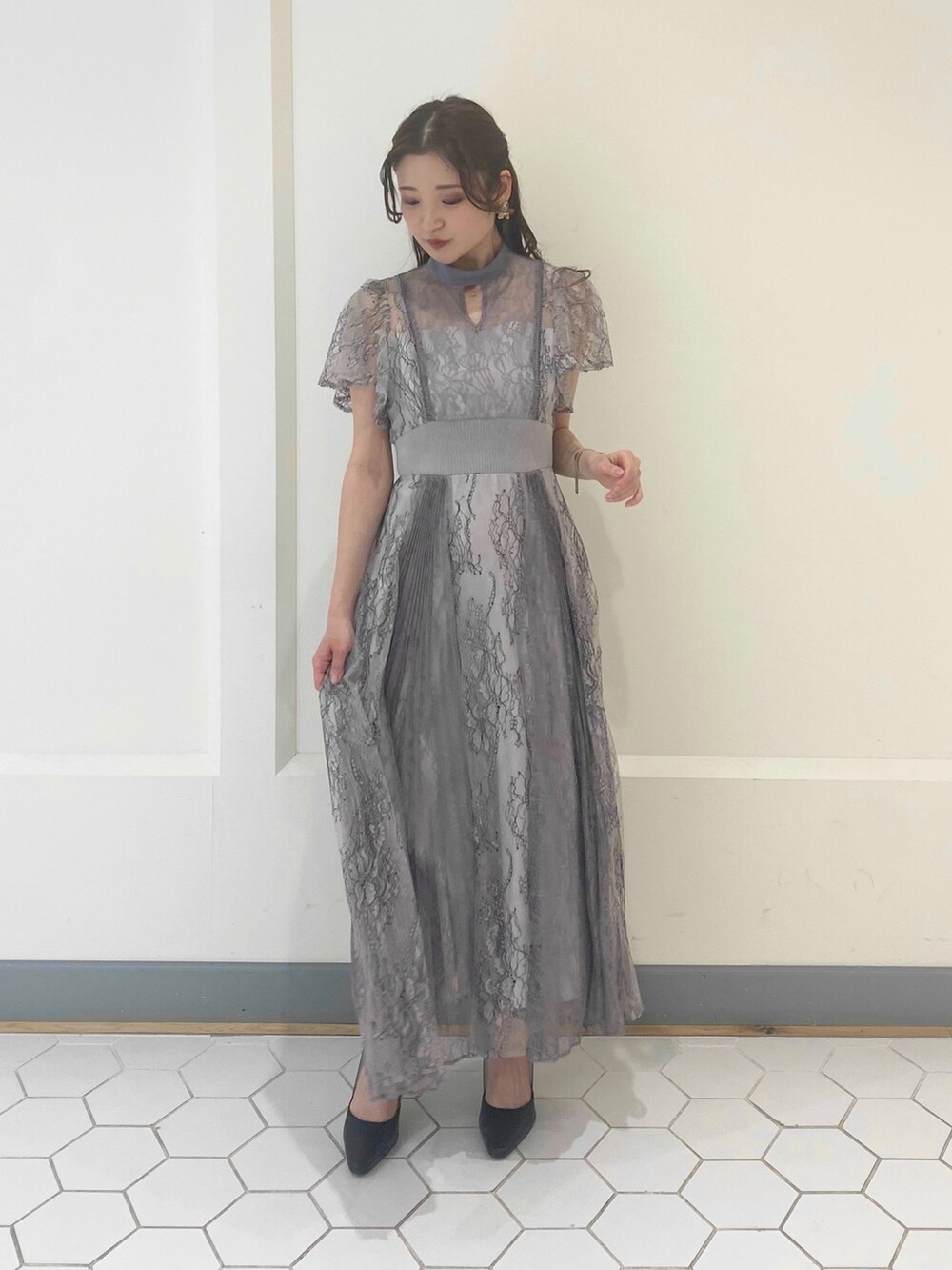 パープル系のドレス、ブラック系のパンプスを着用したレディースの冬コーディネートの2枚目の写真