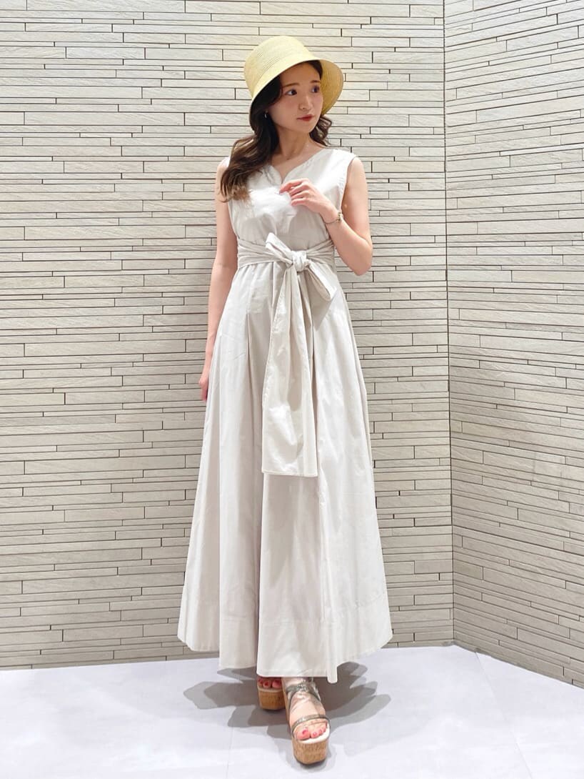 ホワイト系のワンピース、ベージュ系のハットを着用したレディースの春コーディネートの2枚目の写真
