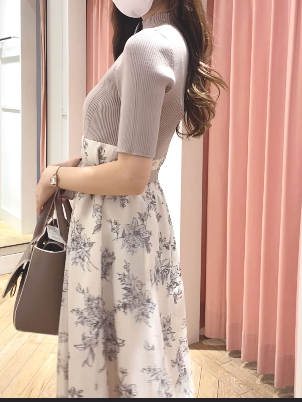 ホワイト系のサンダル、ベージュ系のハンドバッグ、ホワイト系のワンピースを着用したレディースの冬コーディネートの4枚目の写真