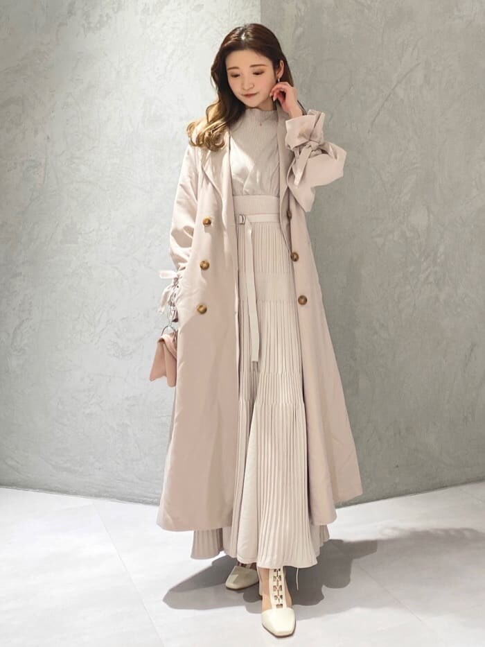 ピンク系のトレンチコートを着用したレディースの冬コーディネートの2枚目の写真