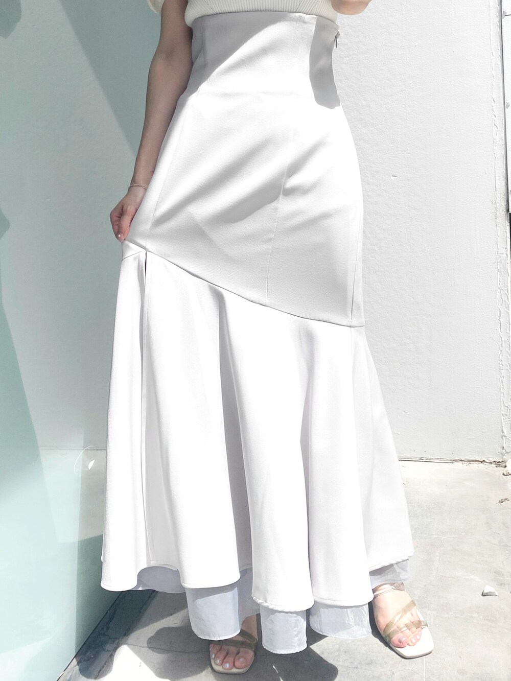 グレー系のスカート、ホワイト系のサンダル、ホワイト系のニット/セーターを着用したレディースの夏コーディネートの7枚目の写真
