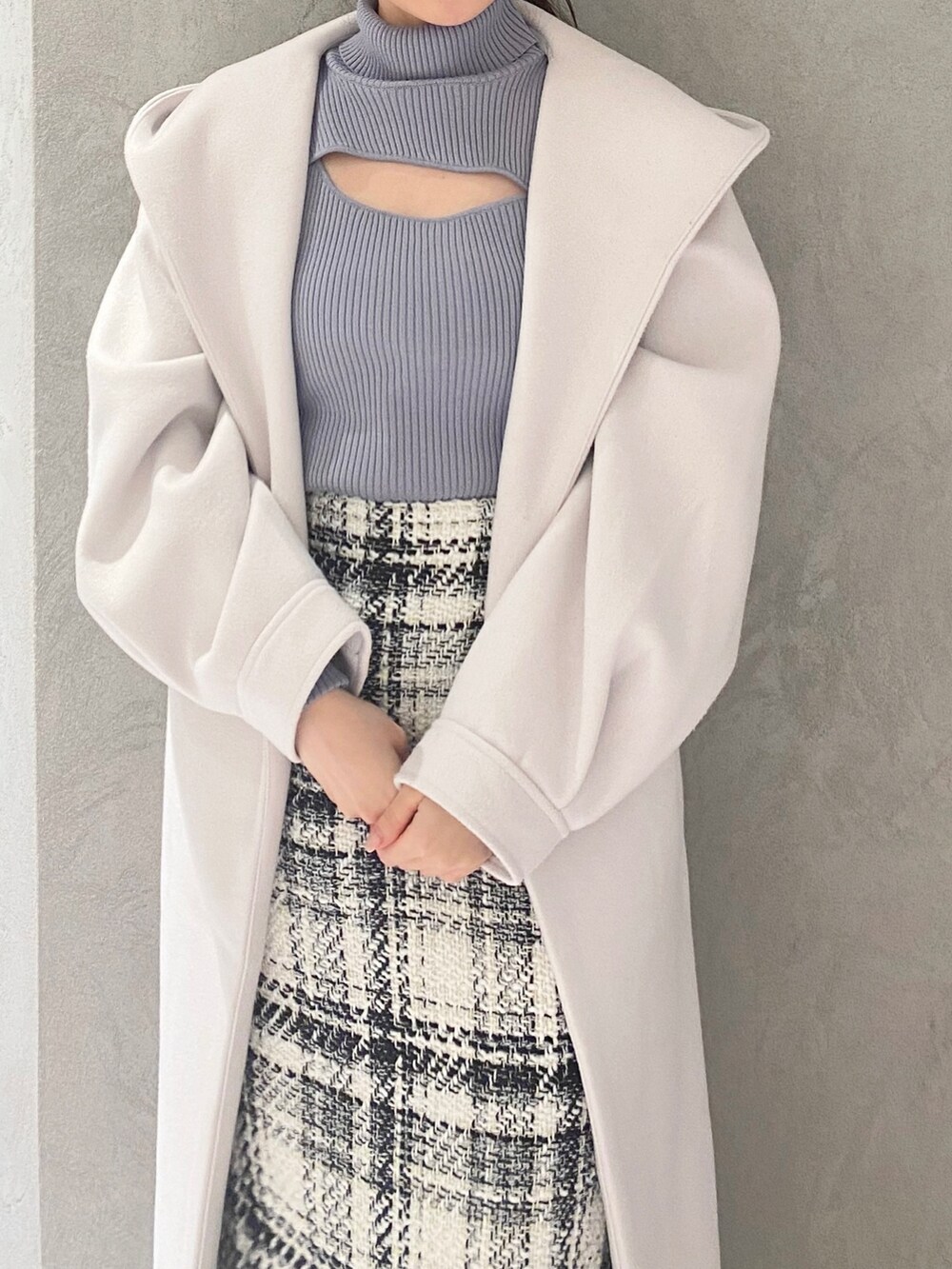 ホワイト系のスカート、ブルー系のニット/セーター、ホワイト系のチェスターコートを着用したレディースの冬コーディネートの7枚目の写真