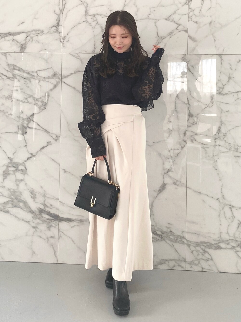 ブラック系のシャツ/ブラウス、ホワイト系のスカート、ブラック系のブーツを着用したレディースの冬コーディネートの2枚目の写真