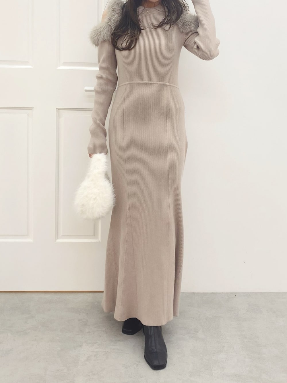 ホワイト系のハンドバッグ、ブラック系のブーツ、ベージュ系のワンピースを着用したレディースの秋コーディネートの2枚目の写真