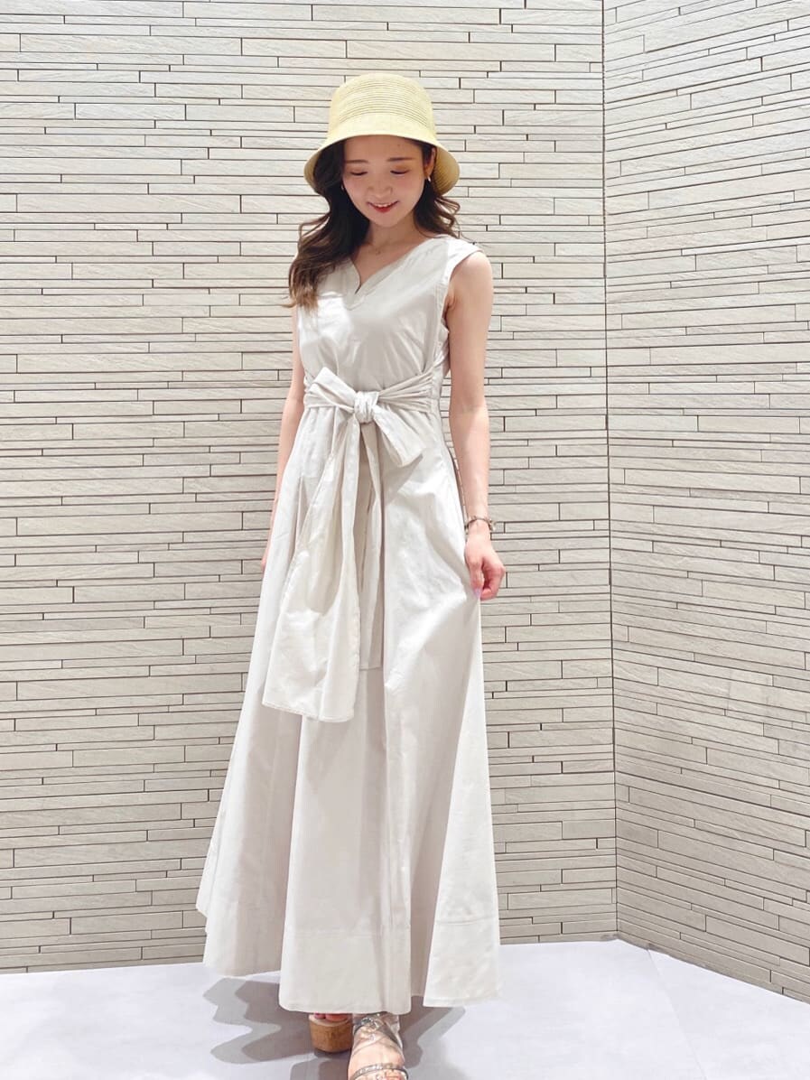 ホワイト系のワンピース、ベージュ系のハットを着用したレディースの春コーディネートの3枚目の写真