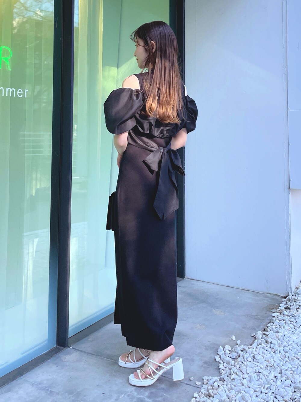 ホワイト系のサンダル、ブラック系のハンドバッグ、ブラック系のワンピースを着用したレディースの春コーディネートの3枚目の写真