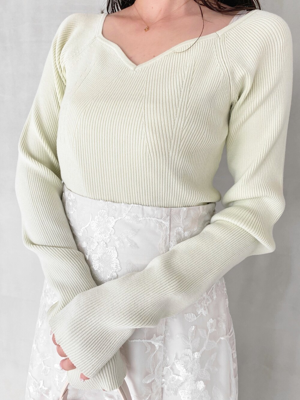 ホワイト系のスカート、ホワイト系のショルダーバッグ、グリーン系のニット/セーターを着用したレディースの秋コーディネートの3枚目の写真