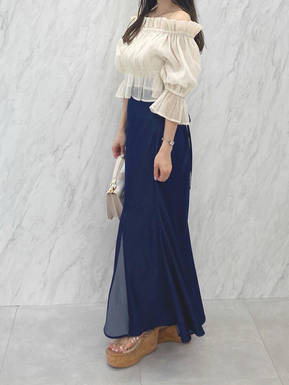 ホワイト系のシャツ/ブラウス、ブルー系のスカート、その他のサンダルを着用したレディースの夏コーディネートの2枚目の写真