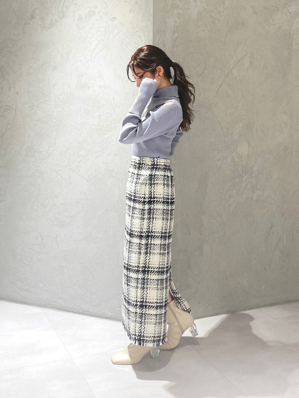 ホワイト系のブーツ、ホワイト系のスカート、ブルー系のニット/セーターを着用したレディースの冬コーディネートの8枚目の写真