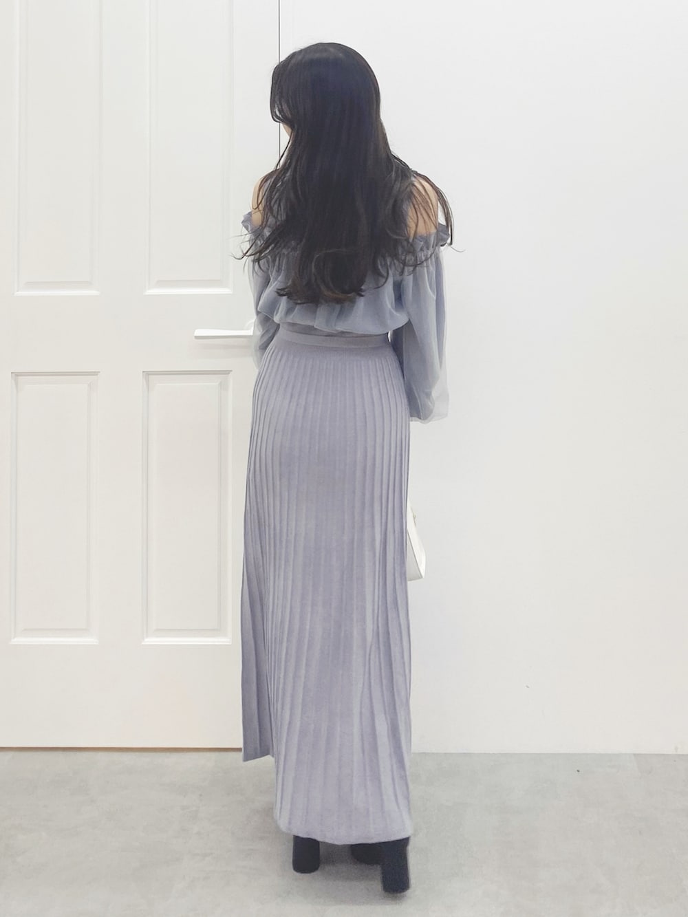 ブラック系のブーツ、ホワイト系のハンドバッグ、ブルー系のワンピースを着用したレディースの秋コーディネートの7枚目の写真