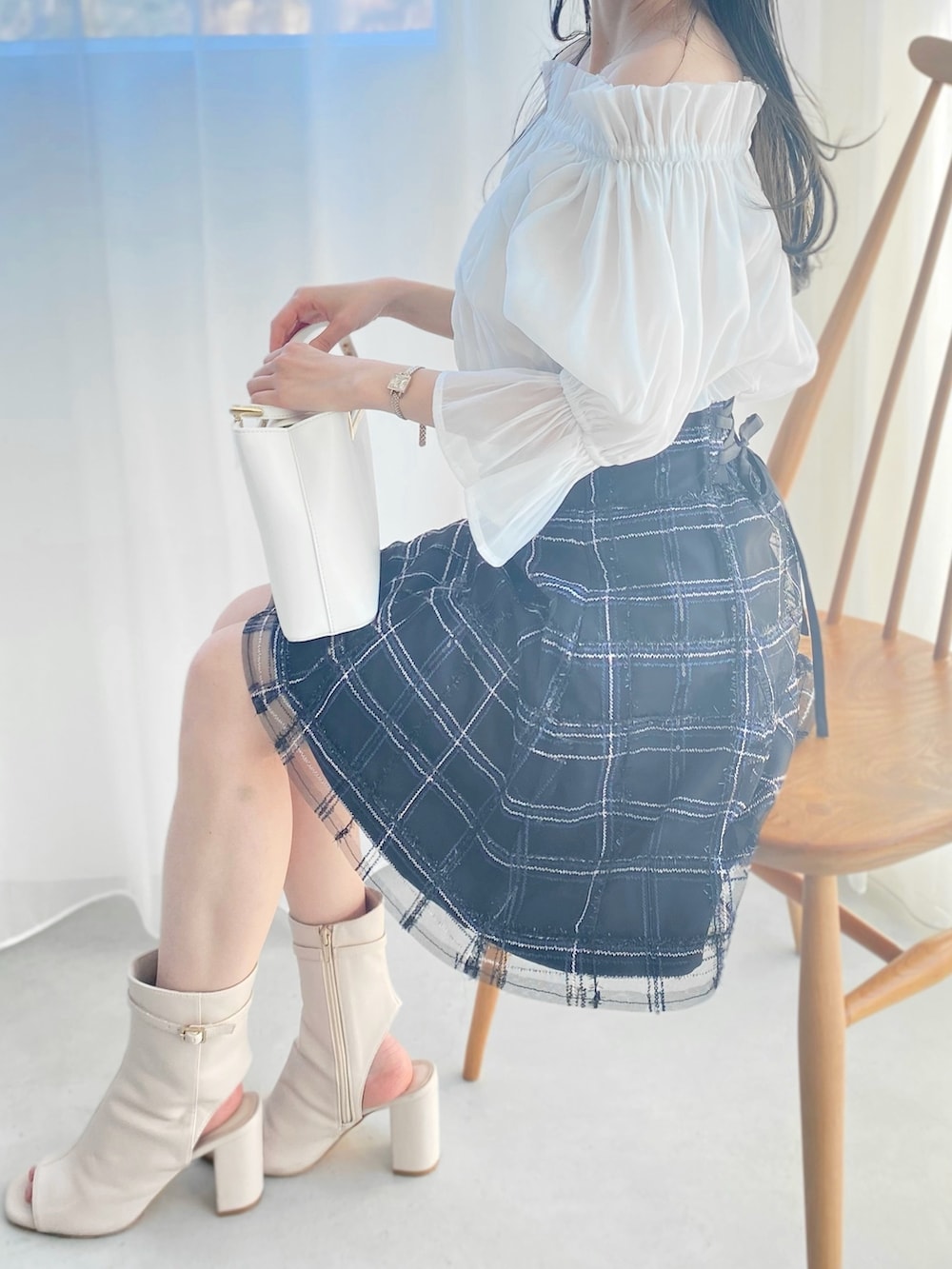 ホワイト系のブーツ、ホワイト系のハンドバッグ、ホワイト系のシャツ/ブラウスを着用したレディースの春コーディネートの2枚目の写真