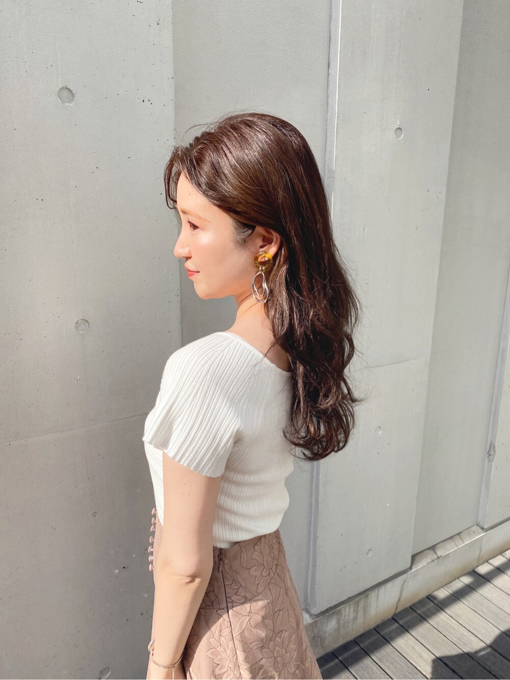 ブラウン系のスカート、ホワイト系のサンダル、ホワイト系のニット/セーターを着用したレディースの春コーディネートの3枚目の写真