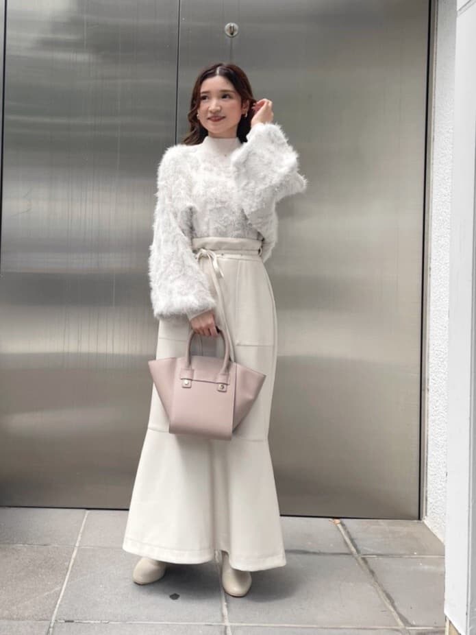 ベージュ系のハンドバッグ、ホワイト系のスカート、ホワイト系のニット/セーターを着用したレディースの秋コーディネートの6枚目の写真