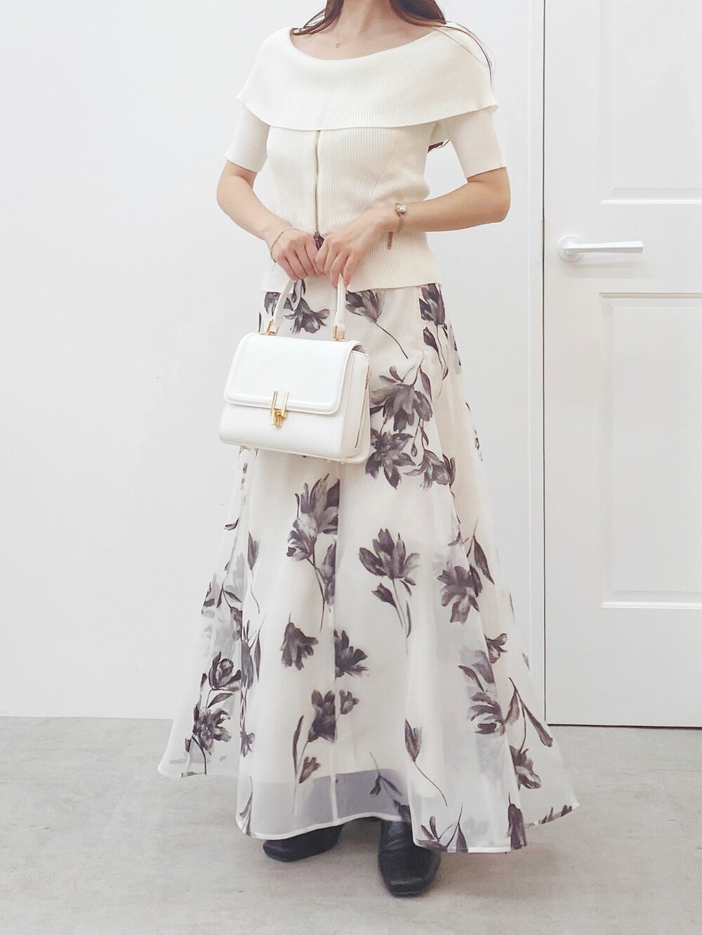 ホワイト系のニット/セーター、ホワイト系のスカート、ホワイト系のハンドバッグを着用したレディースの秋コーディネートの3枚目の写真