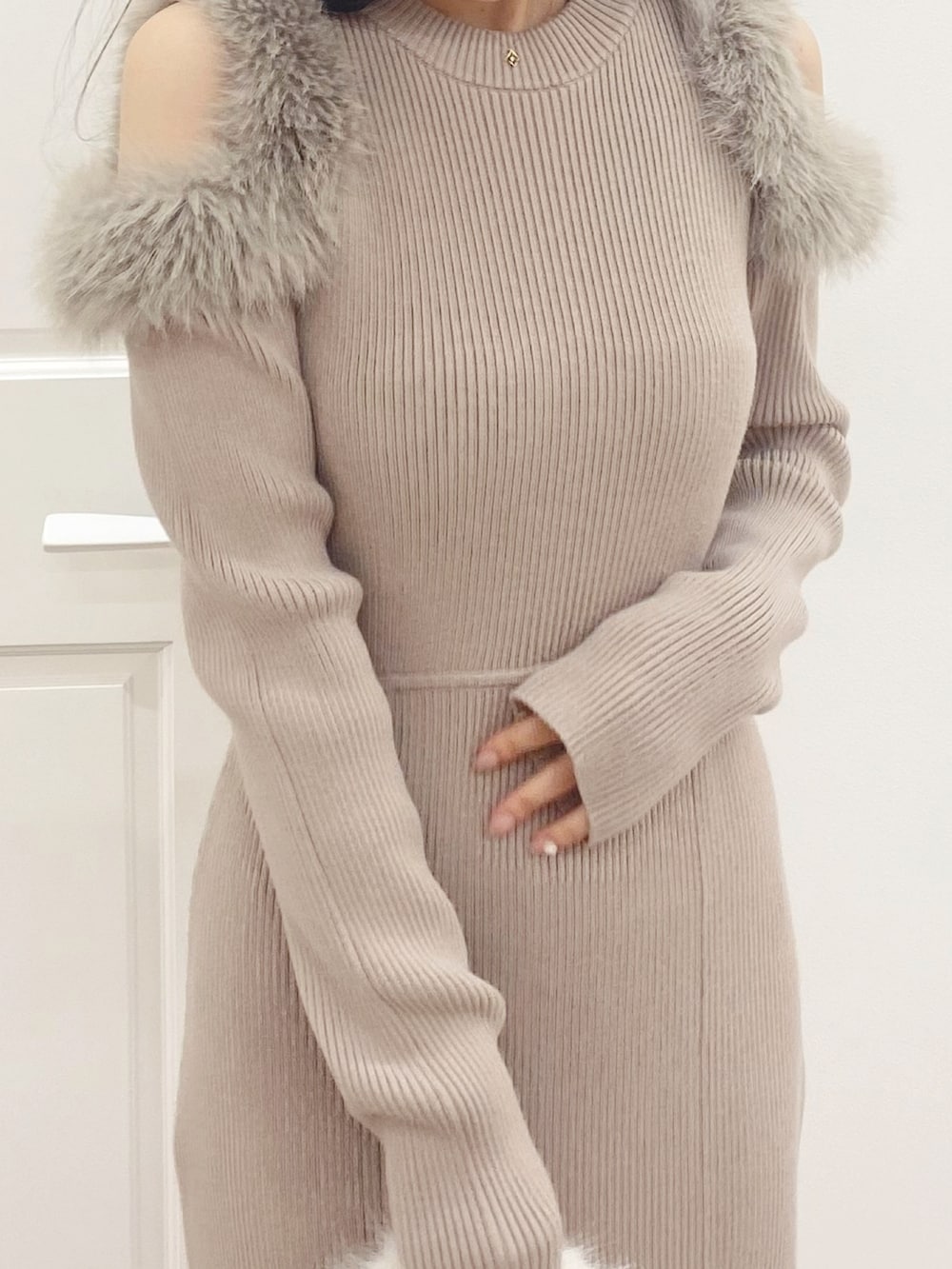 ホワイト系のハンドバッグ、ブラック系のブーツ、ベージュ系のワンピースを着用したレディースの秋コーディネートの6枚目の写真