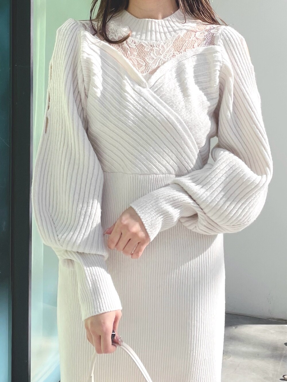 ホワイト系のブーツ、ホワイト系のショルダーバッグ、ホワイト系のワンピースを着用したレディースの冬コーディネートの5枚目の写真