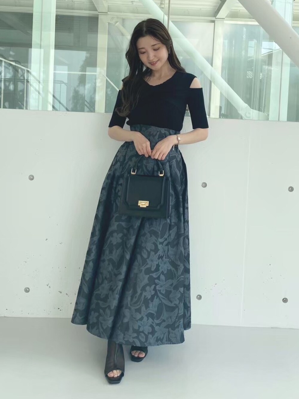 ブラック系のハンドバッグ、ブラック系のブーツ、ブラック系のニット/セーターを着用したレディースの秋コーディネートの3枚目の写真