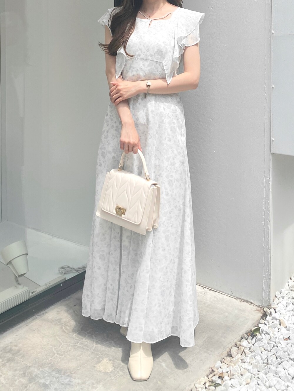 ホワイト系のワンピース、ホワイト系のショルダーバッグを着用したレディースの夏コーディネートの3枚目の写真