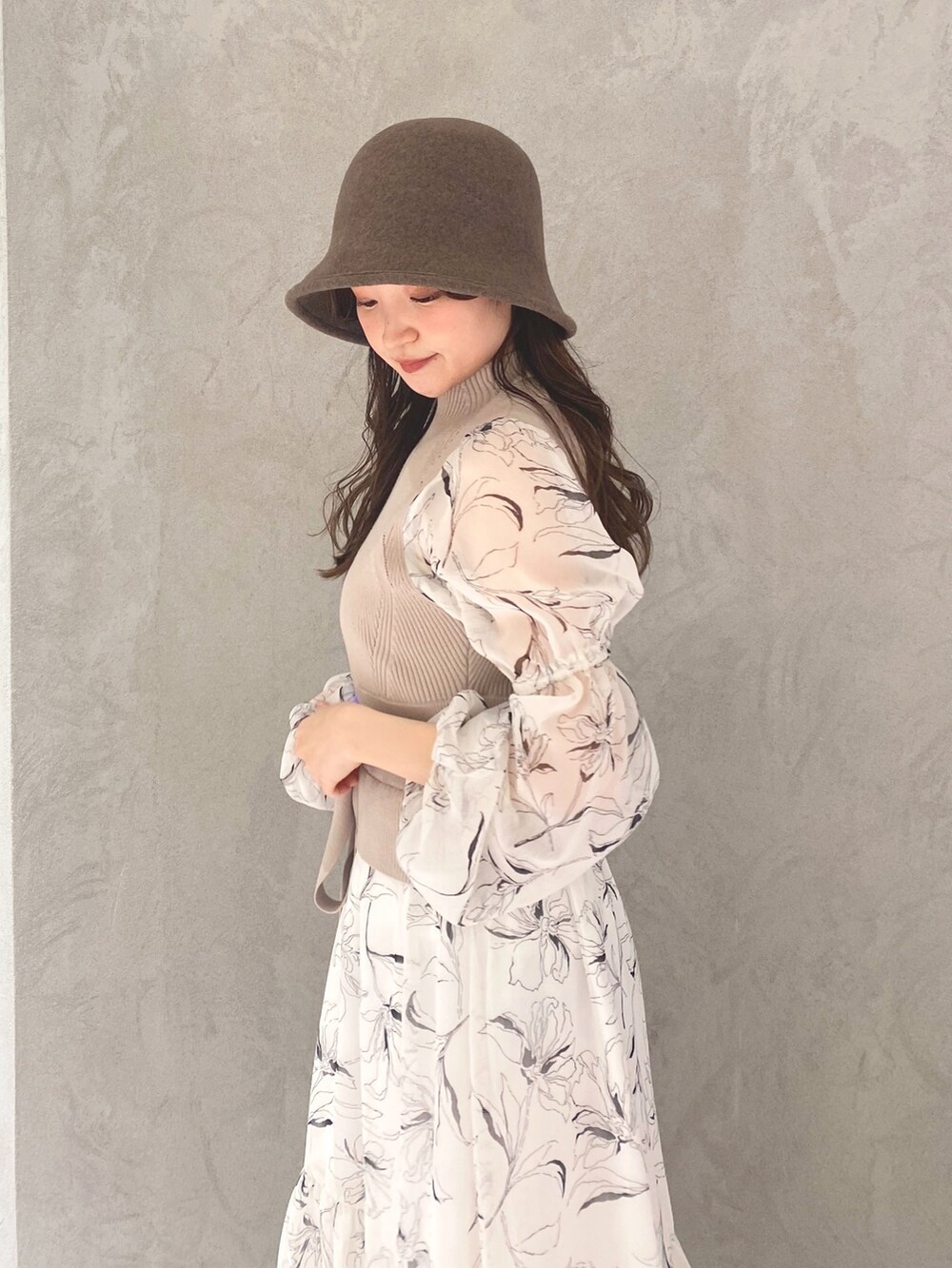 ホワイト系のワンピース、ベージュ系のハンドバッグ、ホワイト系のブーツを着用したレディースの冬コーディネートの7枚目の写真