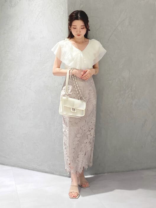 ピンク系のスカート、ベージュ系のサンダル、ホワイト系のカーディガン/ボレロを着用したレディースの夏コーディネートの7枚目の写真