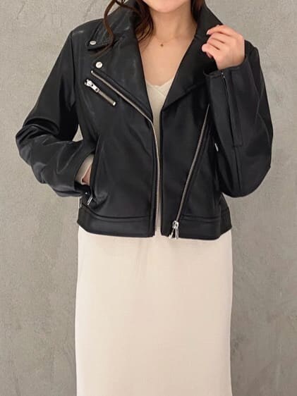 ブラック系のライダースジャケット、ブラック系のブーツ、ブラウン系のハンドバッグを着用したレディースの秋コーディネートの5枚目の写真