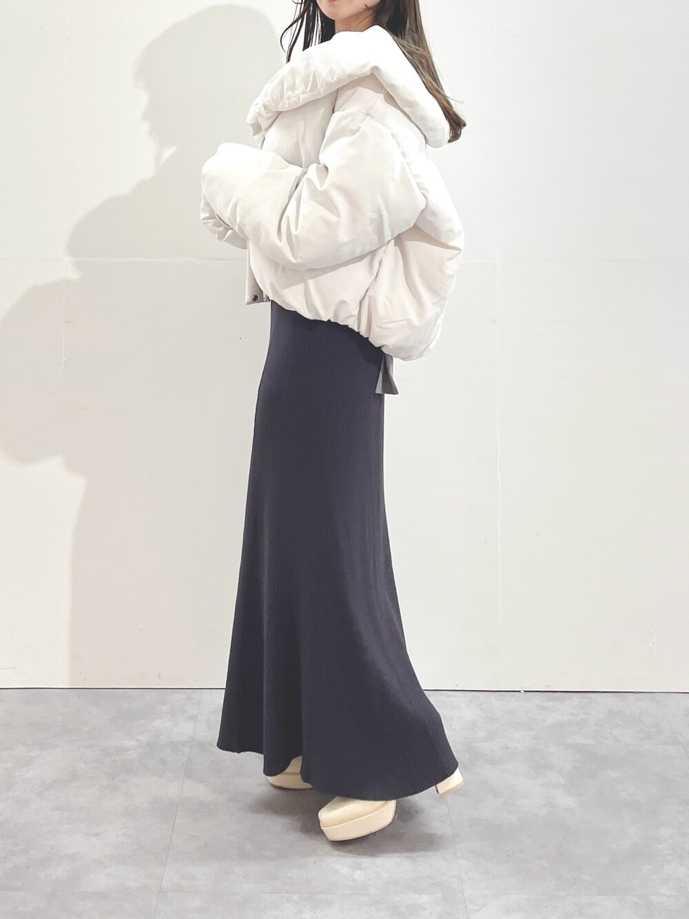 ホワイト系のブーツ、ホワイト系のダウンジャケット/コート、グレー系のワンピースを着用したレディースの冬コーディネートの3枚目の写真