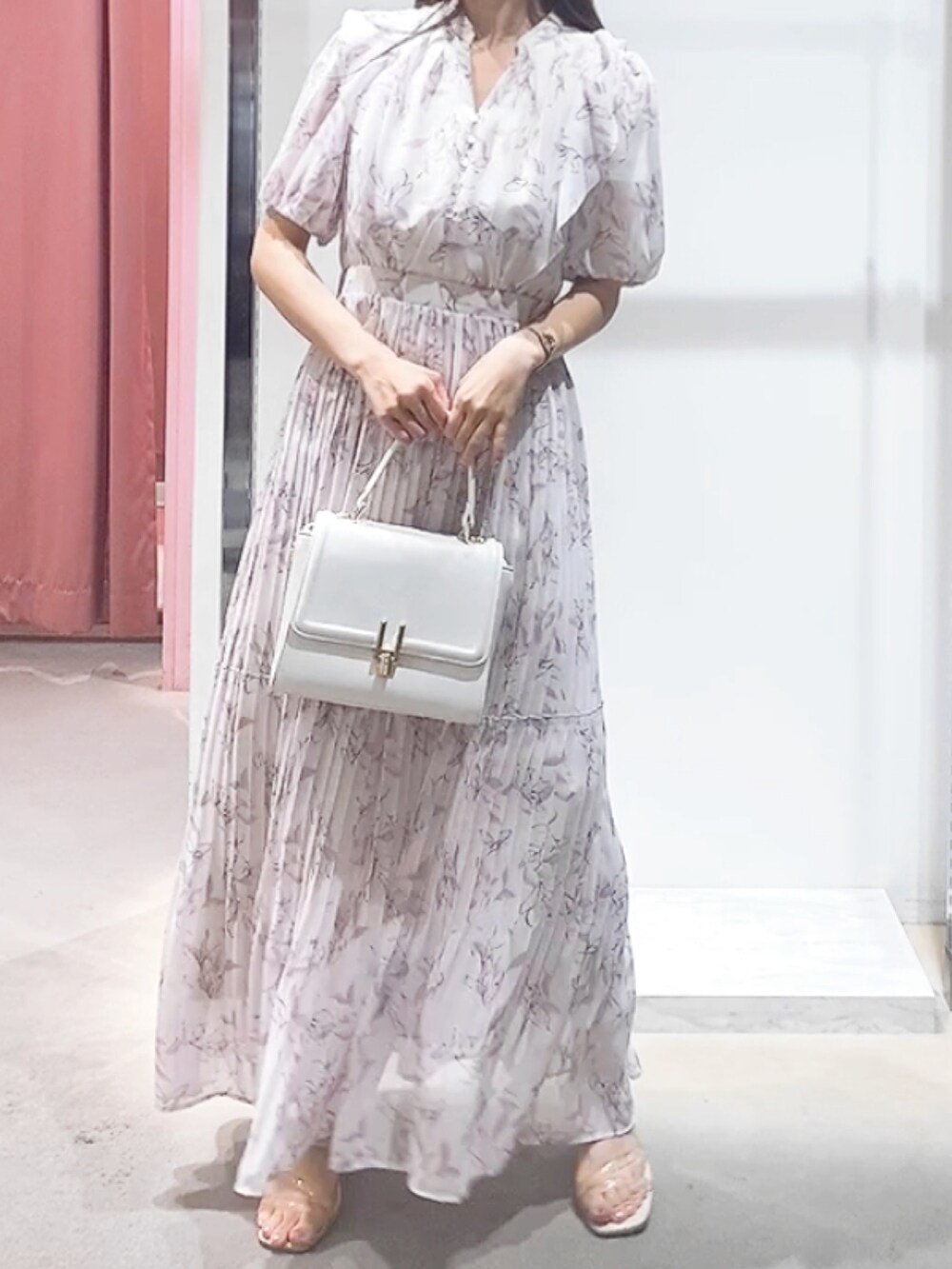 ピンク系のワンピース、ホワイト系のハンドバッグを着用したレディースの夏コーディネートの3枚目の写真