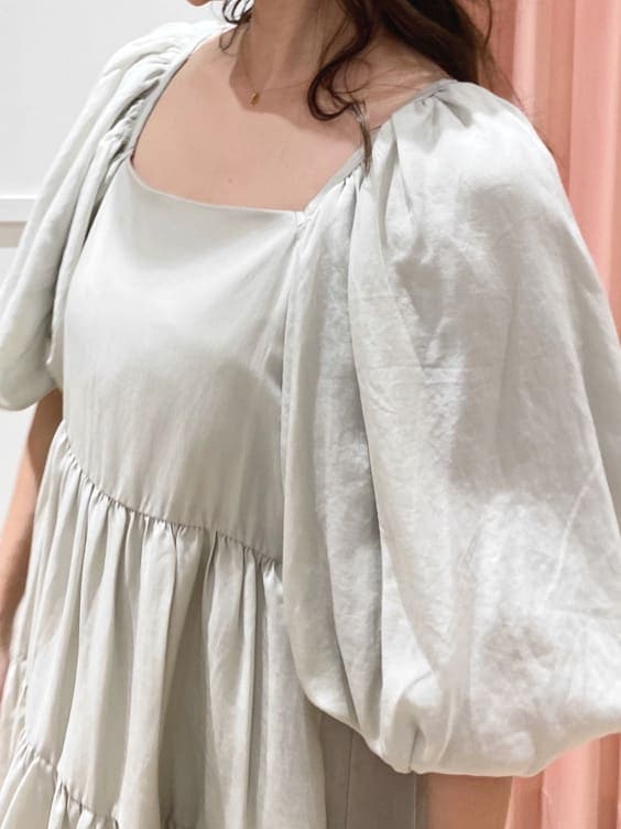 グリーン系のワンピース、ベージュ系のブーツ、ベージュ系のキャスケットを着用したレディースの秋コーディネートの4枚目の写真