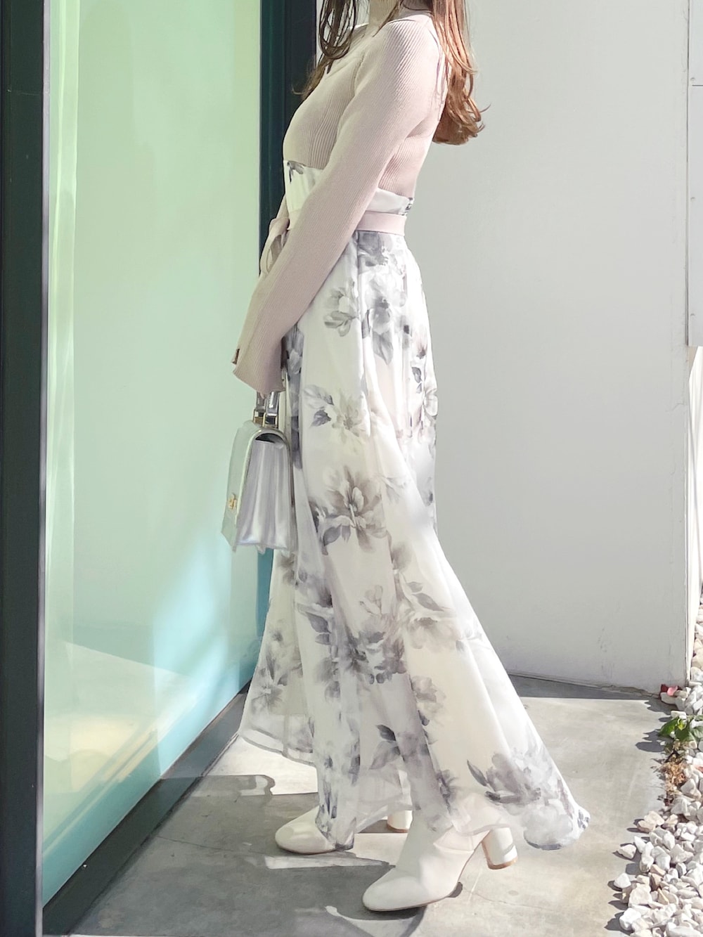 ベージュ系のワンピース、ホワイト系のブーツ、シルバー系のハンドバッグを着用したレディースの冬コーディネートの3枚目の写真