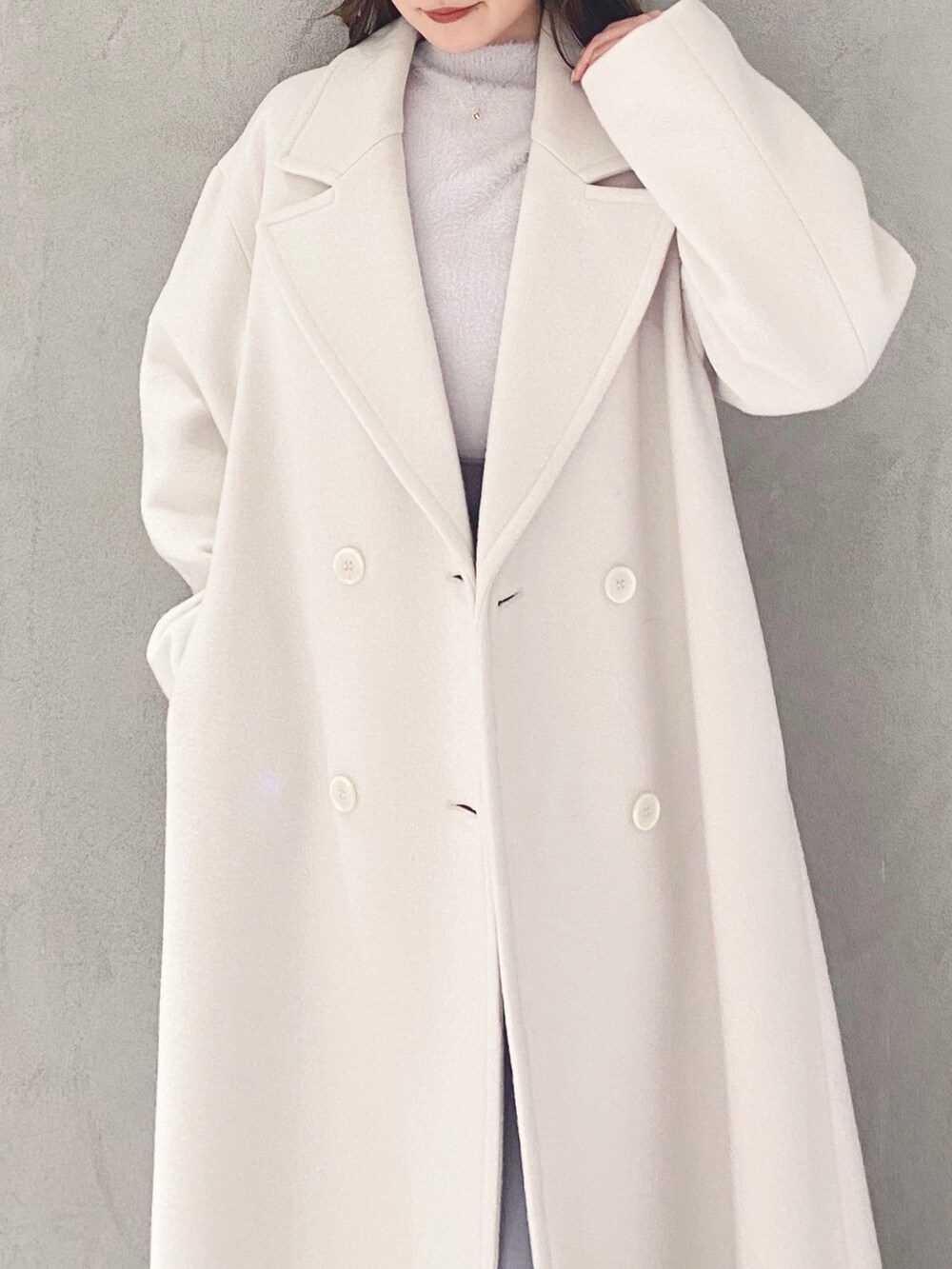 ホワイト系のチェスターコート、ホワイト系のブーツ、パープル系のニット/セーターを着用したレディースの冬コーディネートの4枚目の写真