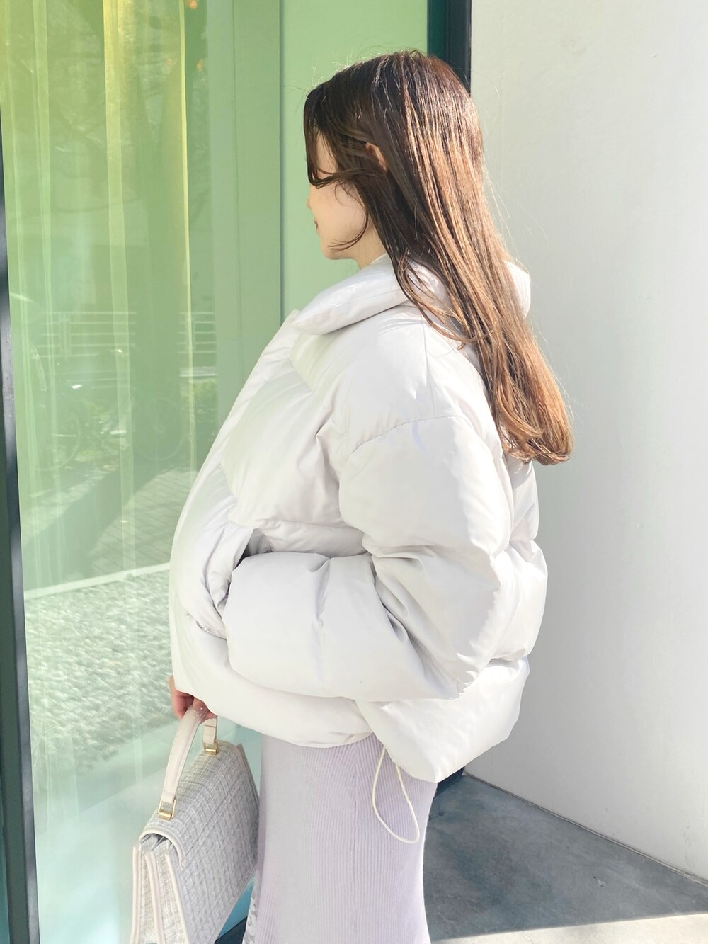 ピンク系のワンピース、ホワイト系のショルダーバッグ、ホワイト系のブーツを着用したレディースの冬コーディネートの3枚目の写真