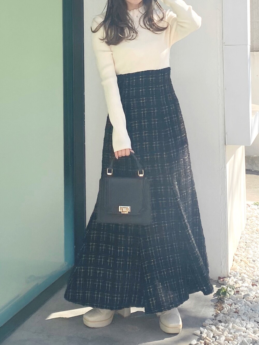 ホワイト系のブーツ、ブラック系のハンドバッグ、ブラック系のワンピースを着用したレディースの冬コーディネートの3枚目の写真