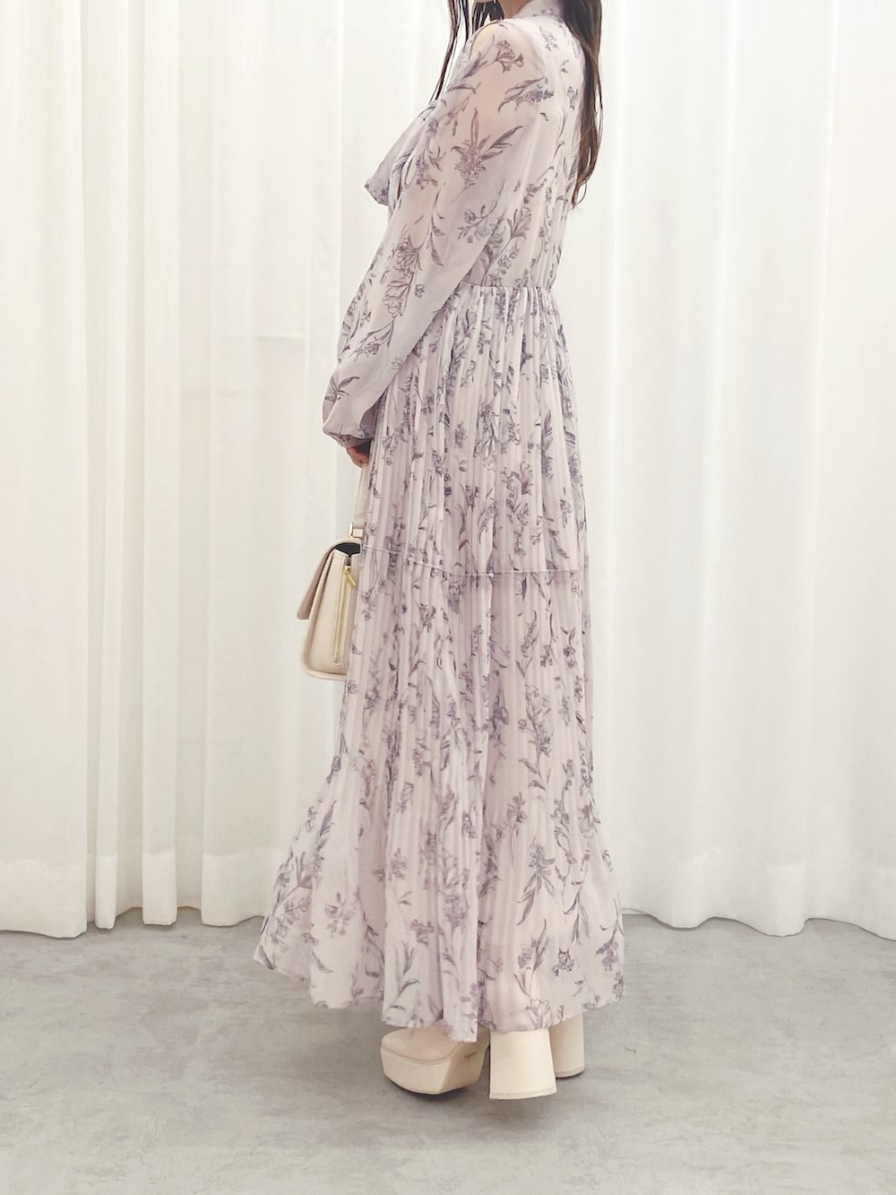 ホワイト系のハンドバッグ、ホワイト系のブーツ、ピンク系のワンピースを着用したレディースの秋コーディネートの4枚目の写真