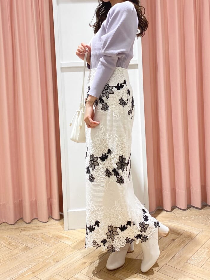 ホワイト系のその他シューズ、ホワイト系のスカート、パープル系のニット/セーターを着用したレディースの秋コーディネートの2枚目の写真