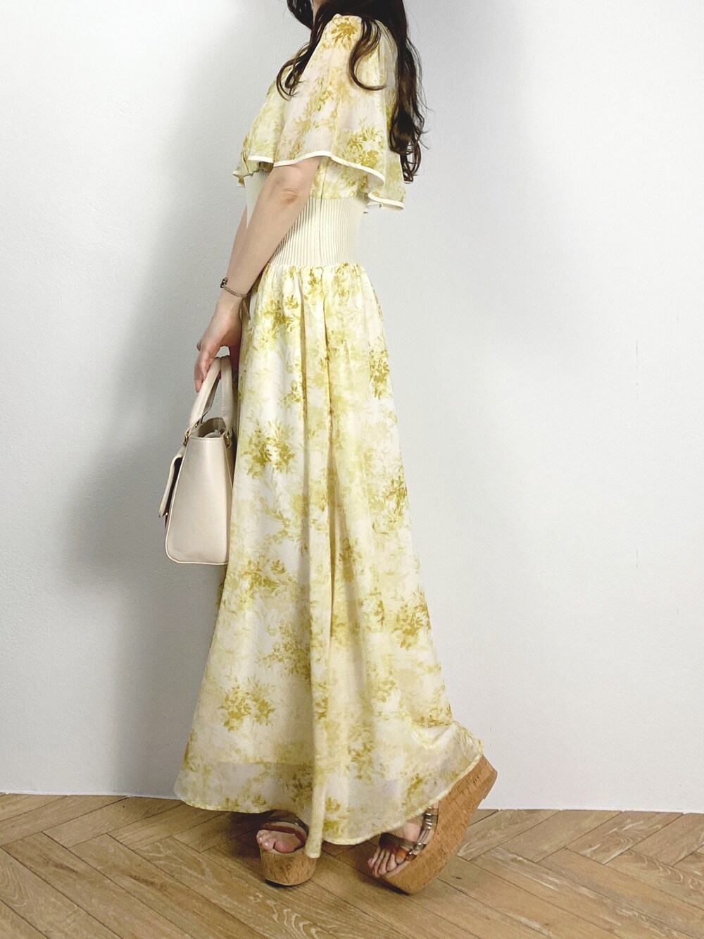 ホワイト系のハンドバッグ、その他のサンダル、イエロー系のワンピースを着用したレディースの夏コーディネートの2枚目の写真