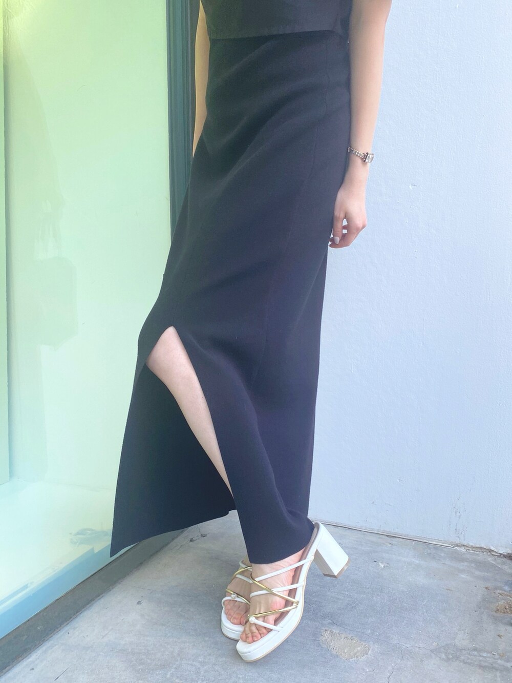 ホワイト系のサンダル、ブラック系のハンドバッグ、ブラック系のワンピースを着用したレディースの春コーディネートの6枚目の写真