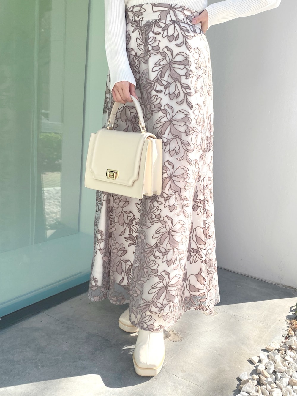 ホワイト系のブーツ、ホワイト系のニット/セーター、ホワイト系のハンドバッグを着用したレディースの冬コーディネートの5枚目の写真