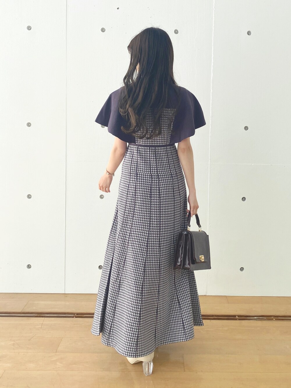 ホワイト系のブーツ、レッド系のハンドバッグ、パープル系のワンピースを着用したレディースの秋コーディネートの4枚目の写真