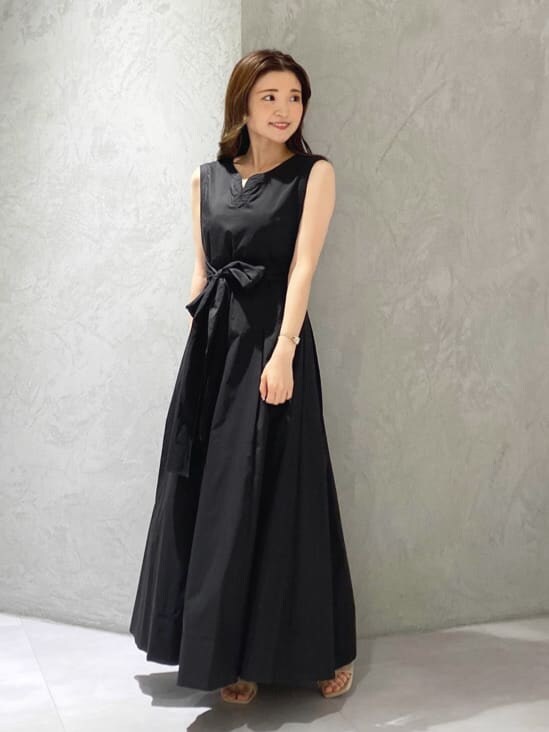 ホワイト系のカーディガン/ボレロ、ブラック系のワンピース、ベージュ系のサンダルを着用したレディースの夏コーディネートの6枚目の写真